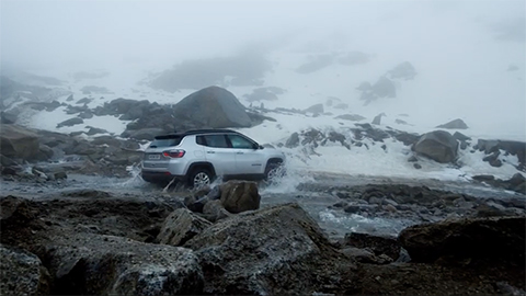 SUV surrounded by snow-covered mountains
