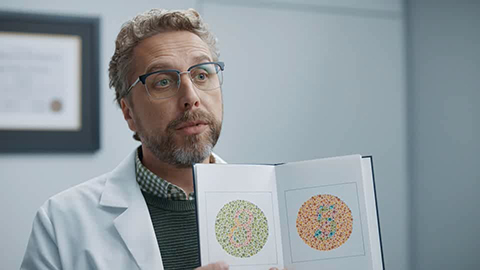 Doctor holding book open to show colorblindness test