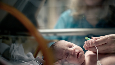 Baby in NICU bed