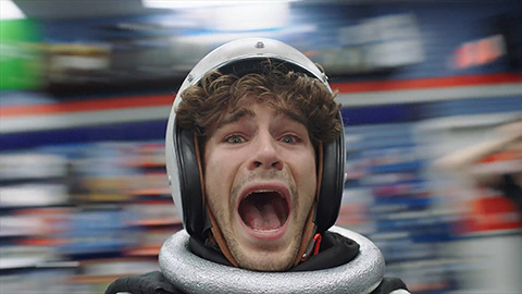 Man wearing helmet screaming as background whirls around him