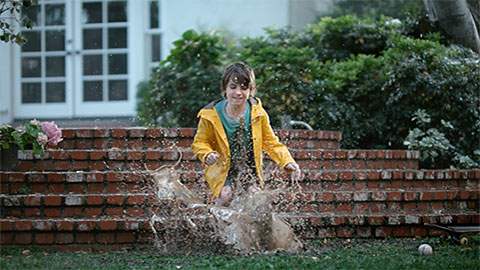 Boy playing in sprinkler