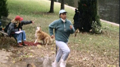 Woman jogging with another woman playing with a dog