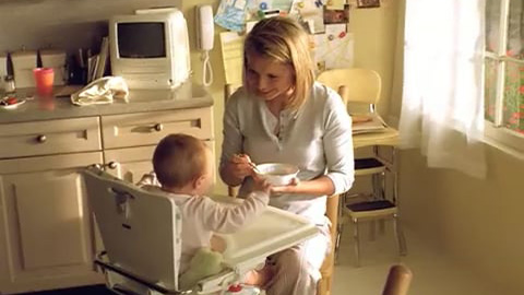 Woman feeding baby in highchair