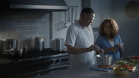 man and woman in kitchen cooking