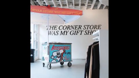 cart in store with 'The corner store was my gift shop' on the wall behind it