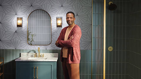 man standing in bathroom with arms crossed